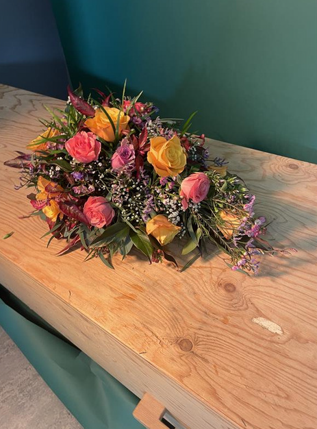 Compact rouwboeket met warme tinten